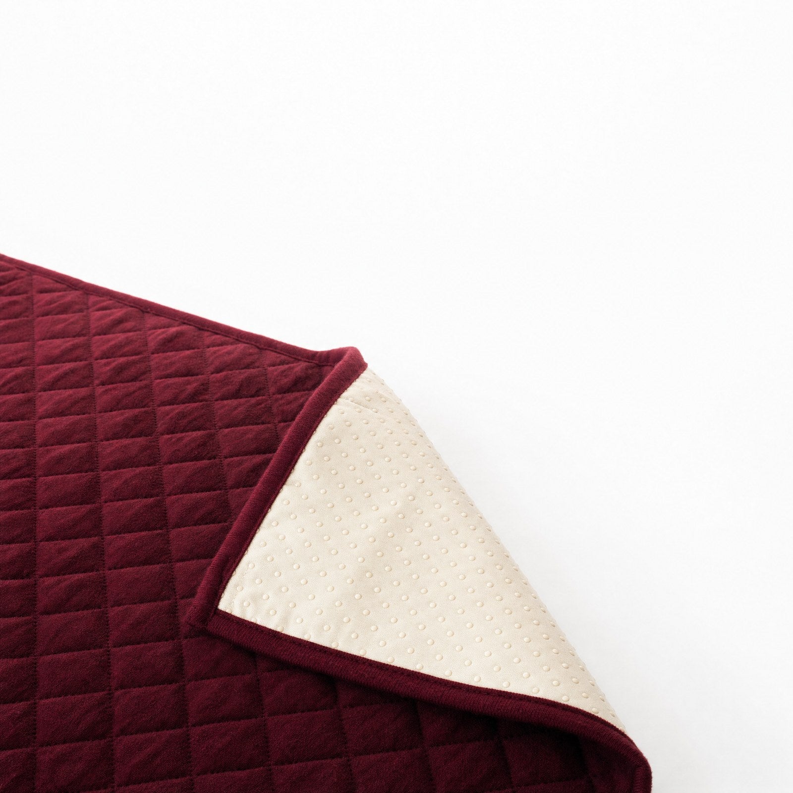 One corner folded back, showing the dotted non-slip backing