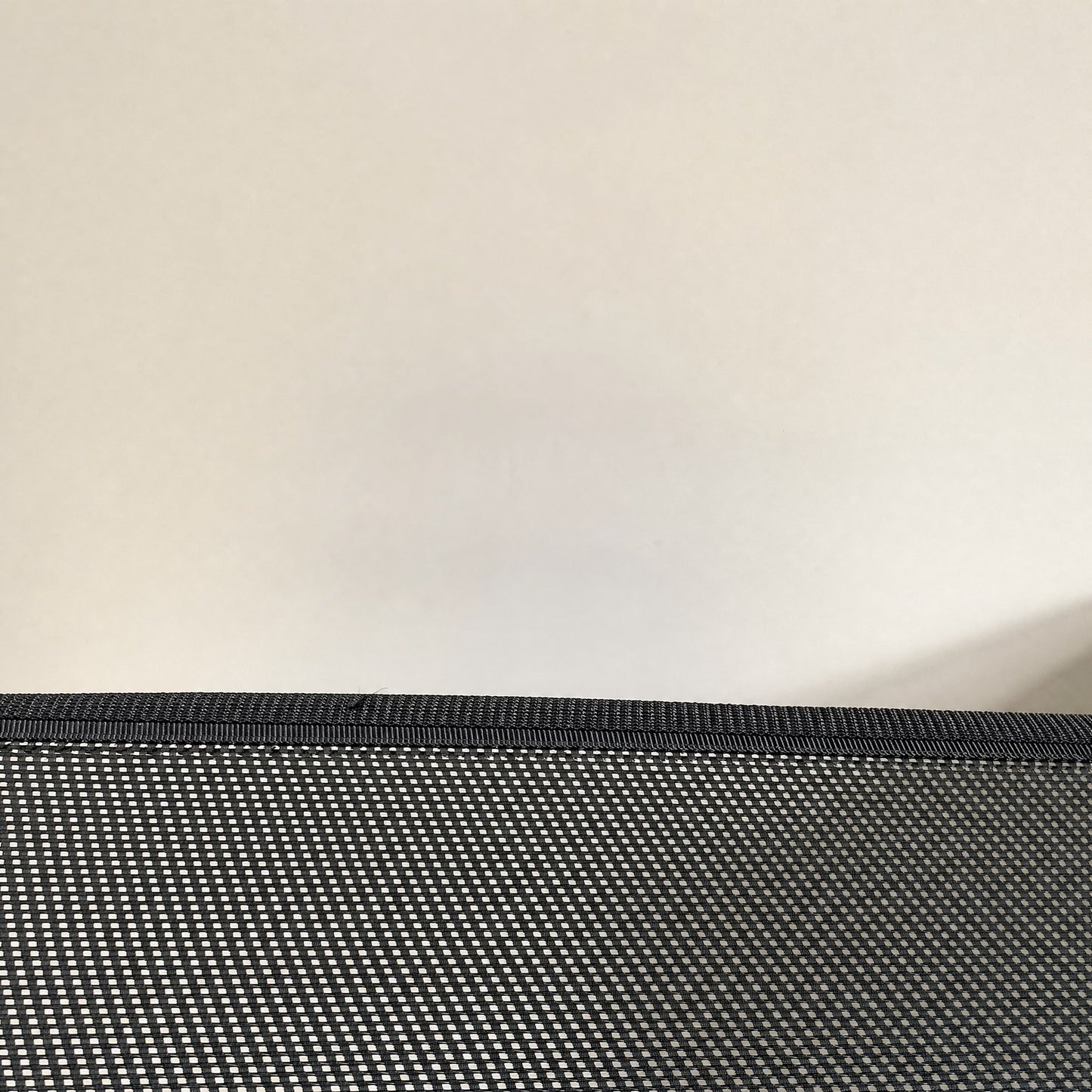 Close-up of the mesh, its open weave and bound edge