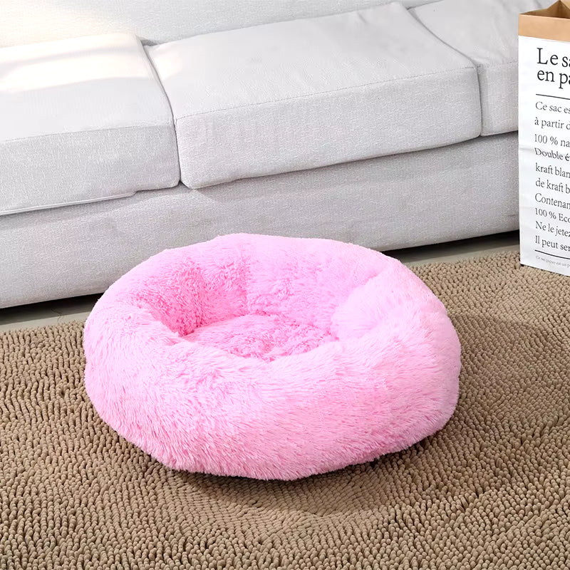A bright pink plush donut dog bed
