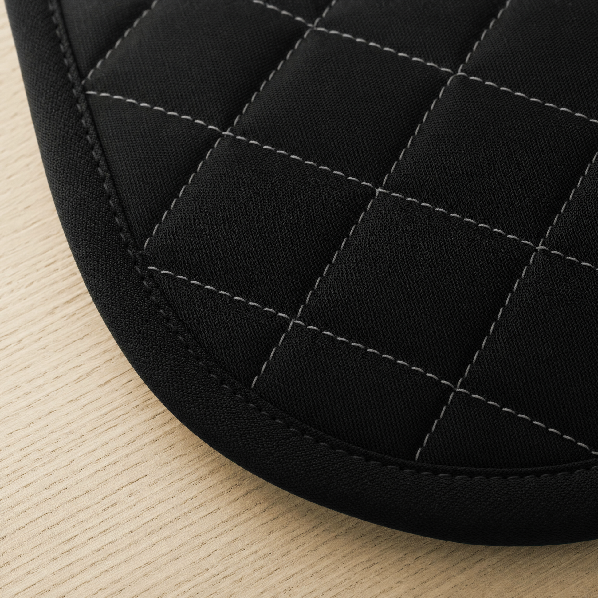 Close-up of the diamond quilting, the grey contrast stitching and the bound edge